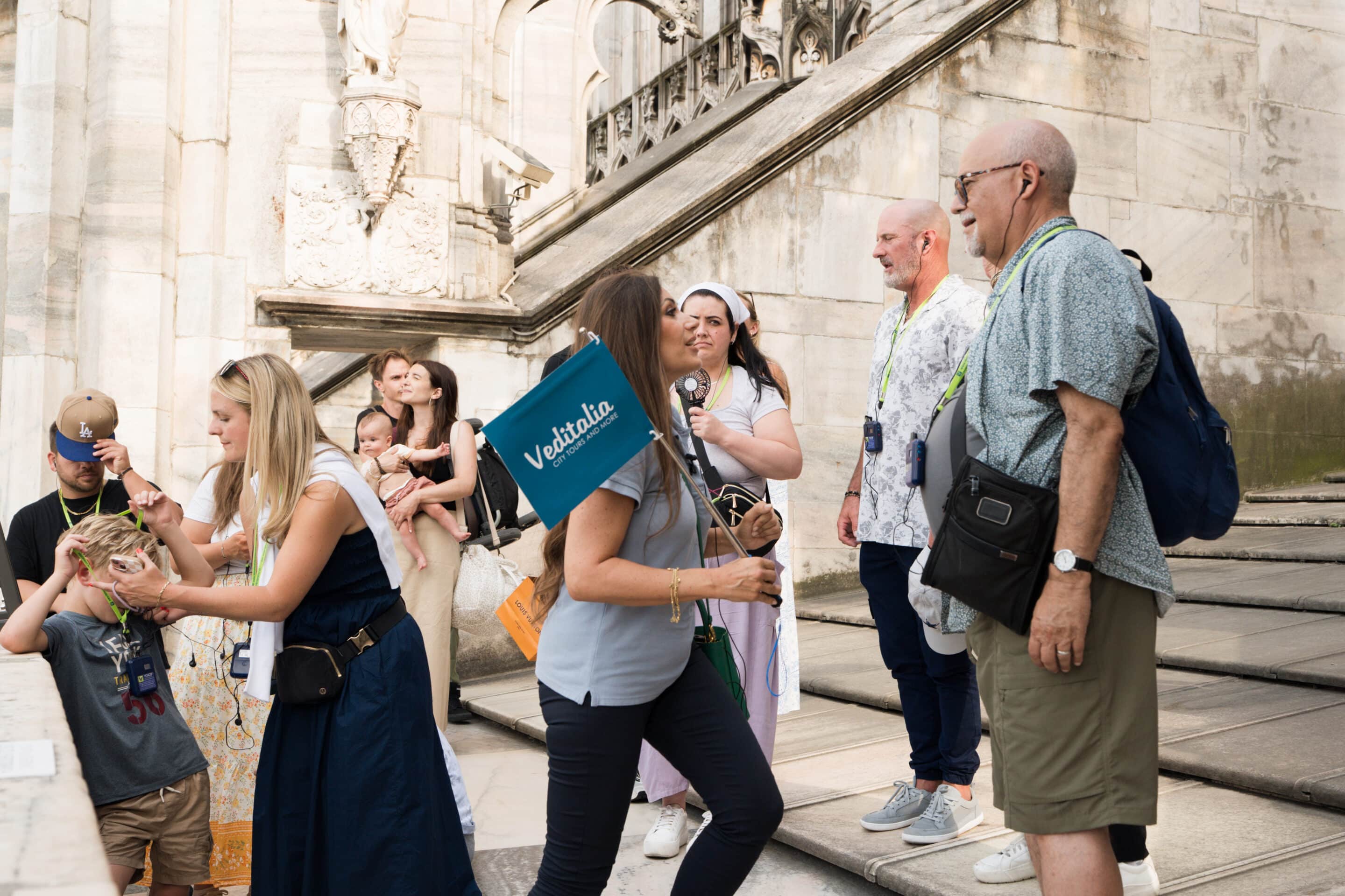 A guided walking tour group on the iconic marble rooftop terraces of the Milan Cathedral (Duomo)